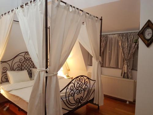 a bedroom with a canopy bed with white curtains at Bucharest Boutique Accommodation by Hotels in Bucharest