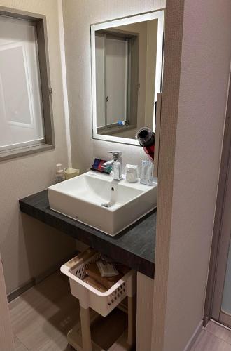 a bathroom with a white sink and a mirror at ホテルZERO in Tanigashira