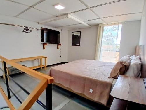 a bedroom with a large bed and a window at Conforto e Praticidade, Studio para 2 pessoas in Ponta Grossa