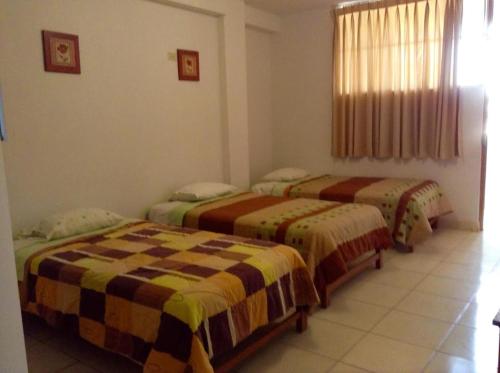 En eller flere senge i et værelse på Hostal La Estancia