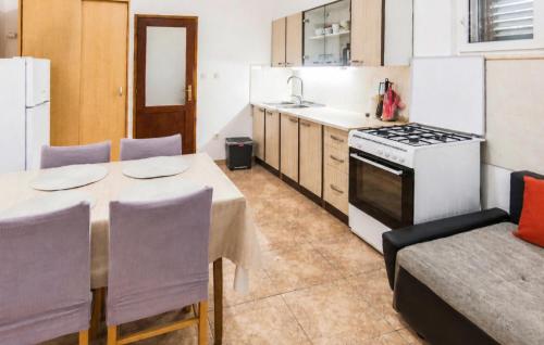 a kitchen with a table and a stove top oven at Holiday Home Pucisca 40 in Pučišća