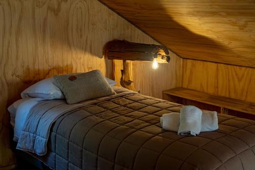 a bedroom with a bed with towels on it at Cabañas Origen Bosque y Río in Melipeuco