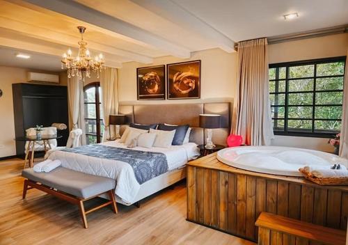 a large bedroom with a large bed and a tub at Hotel Sonnet Curitiba in Curitiba
