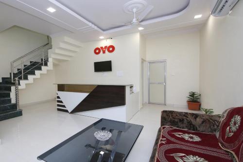 a living room with a couch and a tv on a wall at Hotel O Atithi Home Stay in Garhā