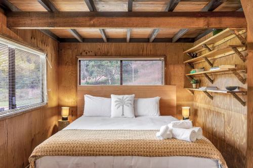a bedroom with a bed in a wooden room at Cascade Springs in North Tumbulgum