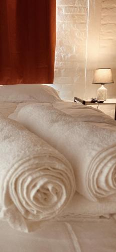 a bed with a white blanket and a lamp on it at Hotel La Morada in Treinta y Tres