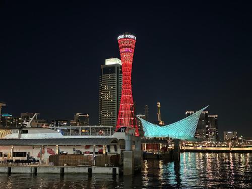 a red tower in the middle of a city at night at Private Inn Bambee in Kobe
