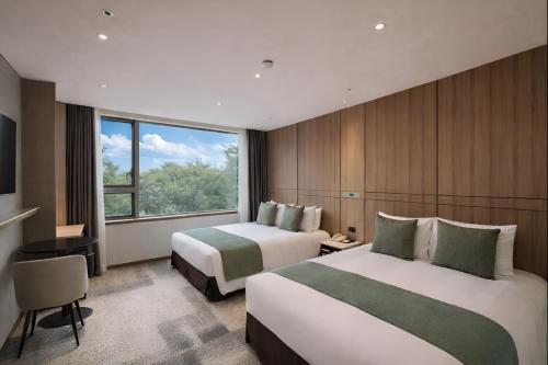 a hotel room with two beds and a window at Golden Seoul Hotel in Seoul