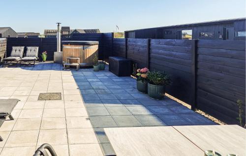 a backyard with a fence and a patio with plants at Awesome Home In Grenaa With Sauna in Grenå
