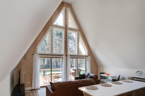 an attic living room with a large window at Secluded Architectural A-Frame w/ Soaring Windows & Fire Pit in South Haven
