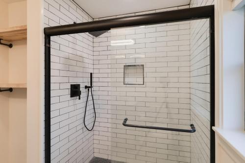 a shower with a glass door in a bathroom at Secluded Architectural A-Frame w/ Soaring Windows & Fire Pit in South Haven