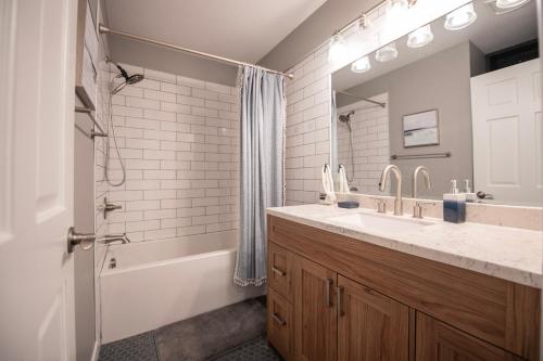 a bathroom with a sink and a tub and a mirror at Newly Renovated Condo in Harborside! in South Haven