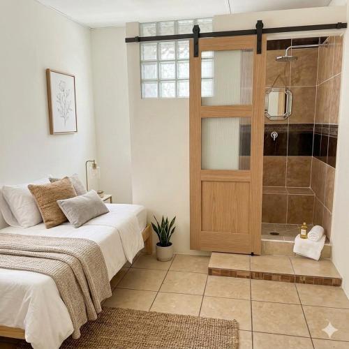 a bedroom with a bed and a shower with a door at Apartamento en San Salvador Cuscatancingo in Cuscatancingo