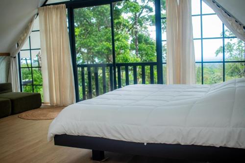 a bedroom with a bed and a balcony with windows at Margaritas House in Buenos Aires