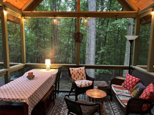 a screened in porch with a table and chairs at Mountainside w Fireplace, Fire Pit, Deck, & WiFi in Smith Crossroads