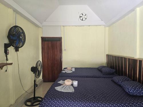 a bedroom with two beds and a fan at Cabanas chaac Calakmul in Xpujil