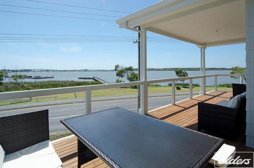 a porch with a table and a view of the water at Riverside Dream - 109 Barrage Rd in Goolwa South