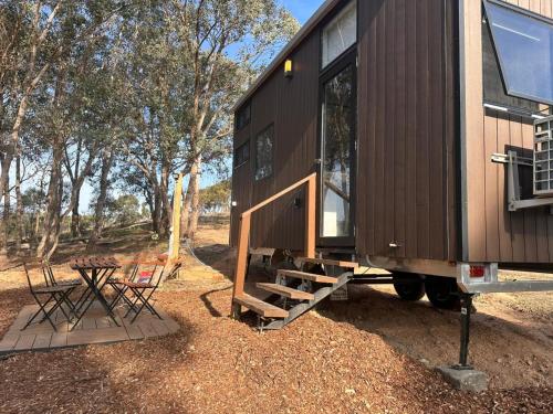a black tiny house with a picnic table and chairs at Tiny House Adventure by Tiny Away in Tallarook