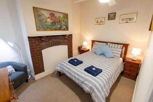 a bedroom with a bed with blue pillows on it at Hawker Bed and Breakfast in Hawker