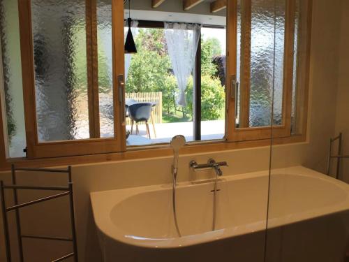 a bath tub in a bathroom with a window at Valomerius Charming holiday home in Maarkedal
