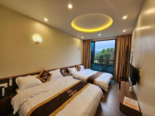 a hotel room with two beds and a window at ZingHome Hà Giang in Ha Giang