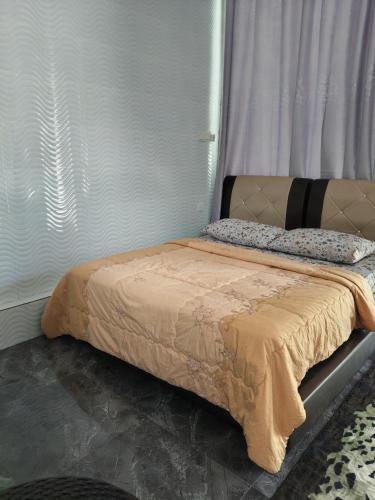 a bed sitting in a room with a window at Makwan Homestay C in Kubang Semang