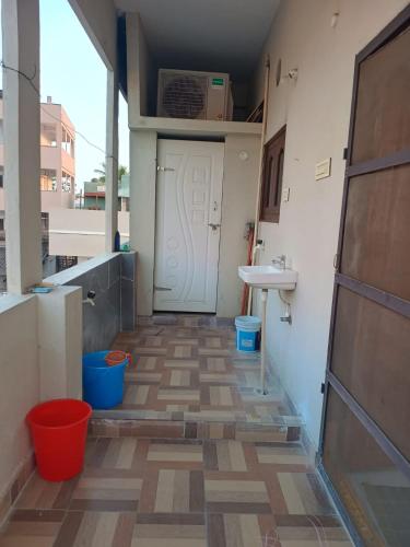 a hallway with a white door and a sink at Sri Durga Nilayam in Bhadrāchalam