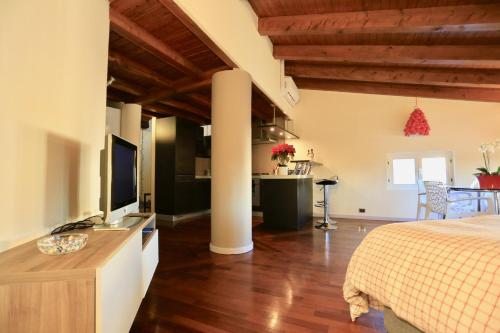 a room with a bed and a kitchen with a television at Casa Vacanze Funicolare in Bergamo