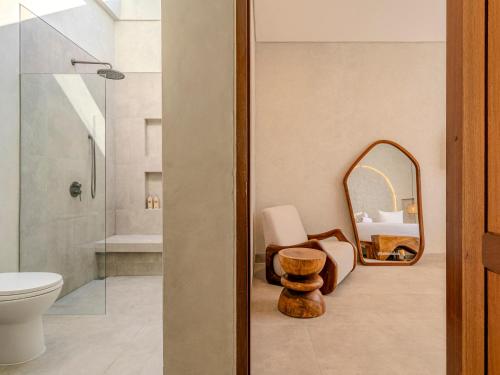 a bathroom with a toilet and a mirror at Kala Lombok Hotel in Kuta Lombok