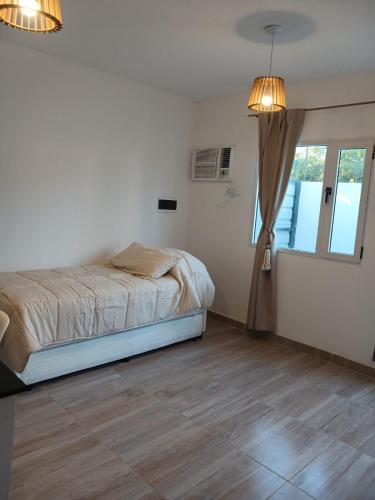 a white bedroom with a bed and a window at Listo para vos in RSA