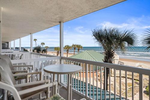 a balcony with a table and chairs and the beach at Oceanfront 1BR Condo Daytona Resort Pool Access in Daytona Beach