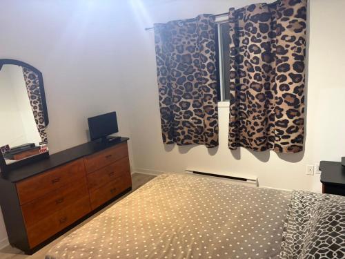 ein Schlafzimmer mit einem Bett und einer Kommode mit Spiegel in der Unterkunft EasyStay in Sherbrooke