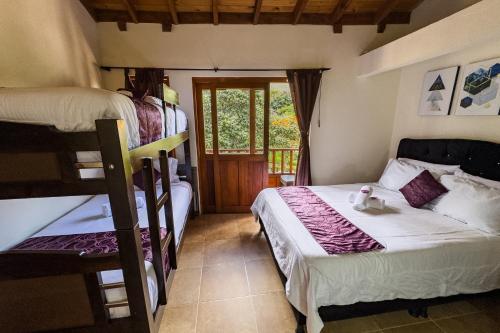 a bedroom with two bunk beds and a balcony at Apartahotel Balcones de Nariño in Villa de Leyva