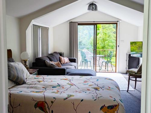a living room with a bed and a couch and a patio at Friends With Bienefelts in Turners Beach