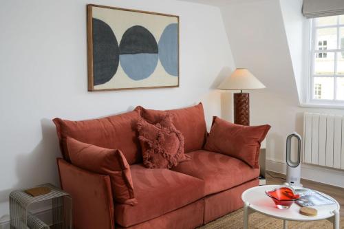a red couch in a living room with a table at Milsom Loft in Bath