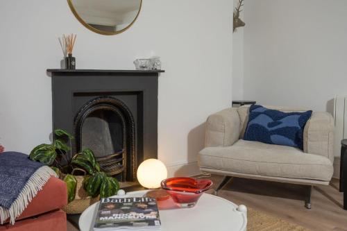 a living room with a chair and a fireplace at Milsom Loft in Bath