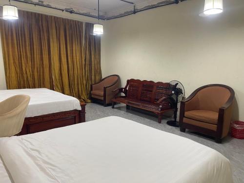 a room with two beds and two chairs and a window at Authentic Joe homestay in Siem Reap