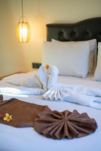 two swans made out of towels on a bed at Lala Panzi Villa by Manara in Jimbaran