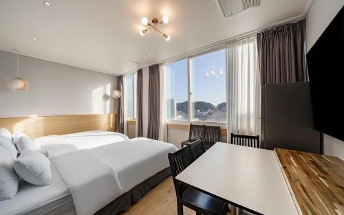 a hotel room with a bed and a table at Incheon The Rest Hotel in Incheon