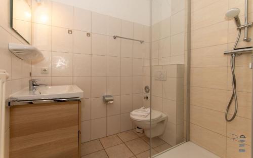 a bathroom with a shower and a toilet and a sink at Wattschnecke in Böhl