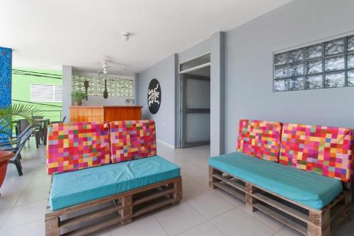 a living room with two chairs with colorful cushions at Oleajes Capurganá in Capurganá