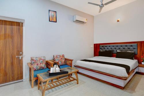 a bedroom with a bed and a table and chairs at Super Hotel O Greater Noida West Link Road Formerly Advent in Noida