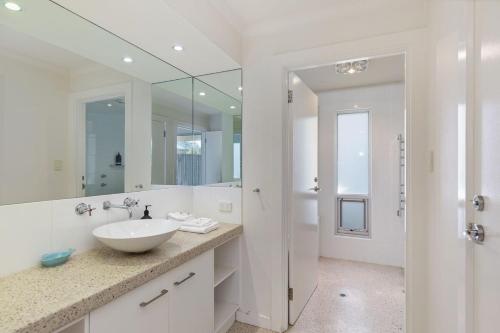 a white bathroom with a sink and a mirror at Indigo Blue in Robe
