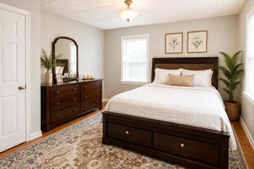 a bedroom with a bed and a dresser and a mirror at Fall River Stay Urban Haven Entire Suites Cozy 4BR in Fall River