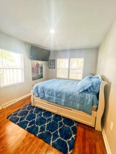 a bedroom with a bed and a blue rug at Triple Crown KC in Kansas City