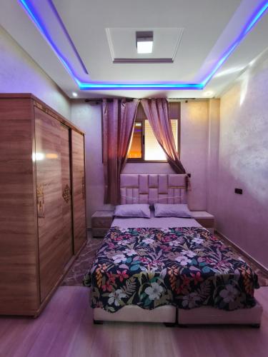 a bedroom with a bed in a room with blue lights at شقة مفروشة للكراء اكادير للعائلات فقط in Agadir