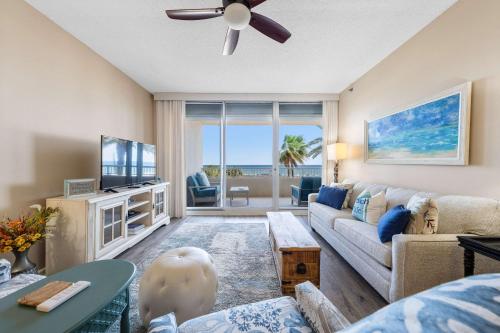 a living room with a couch and a tv at 2BR Beach Condo Shared Pool Tennis Courts in Gulf Shores