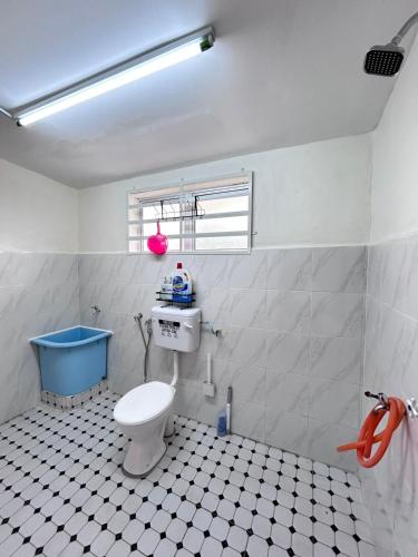 a bathroom with a toilet and a blue tub at Homestay Teera in Chemor