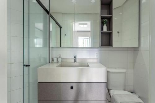 a white bathroom with a sink and a toilet at Apt Boutique Grande Florianópolis - Sua Estadia SC in São José