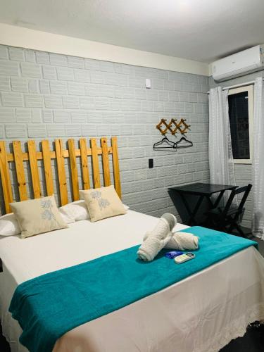a bedroom with a large bed with a blue blanket at Pousada Portal D'amaro in Santo Amaro